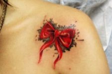 Watercolor red bow tattoo on the shoulder