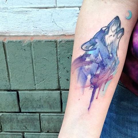 Wolf and moon tattoo on the arm