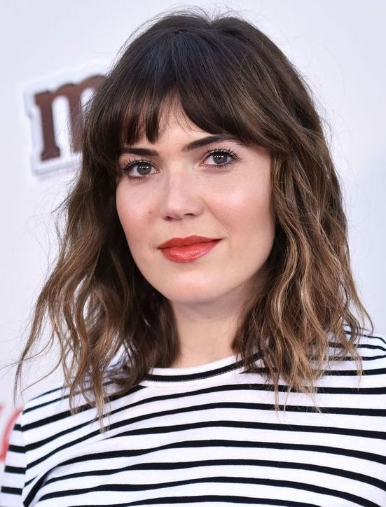 A long dark brunette bob with bronde balayage, bottleneck bangs and waves is a chic and French inspired idea