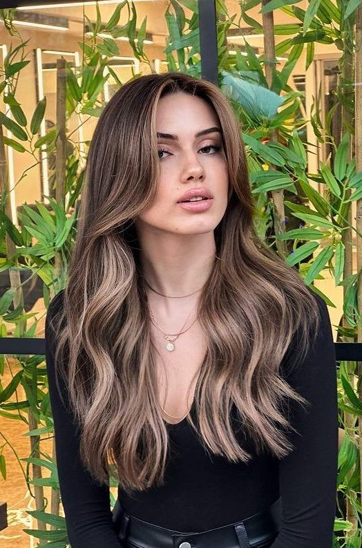 dark brown hair with bronde highlights and waves plus long curtain bangs looks chic, fresh and bright