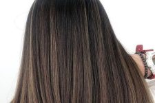 dark brunette hair with delicate caramel and gold babylights that bring dimension and volume to the hair