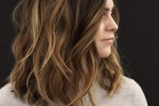 dark brunette medium-length hair with golden blonde balayage, messy waves and volume is a stunning idea