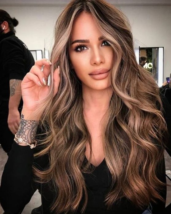 long brunette hair with caramel and blonde highlights and waves looks gorgeous and very chic