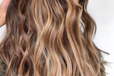 long wavy brunette hair with sunkissed balayage is a pretty idea for summer that doesn’t require much maintenance