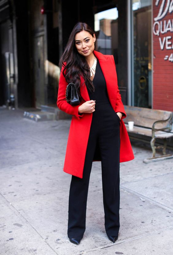 a black jumpsuit with a cutout and a red coat are enough for a holiday look