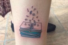 Book with flying letters tattoo