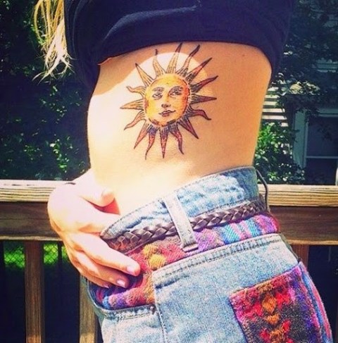 Eye-catching sun tattoo on the side