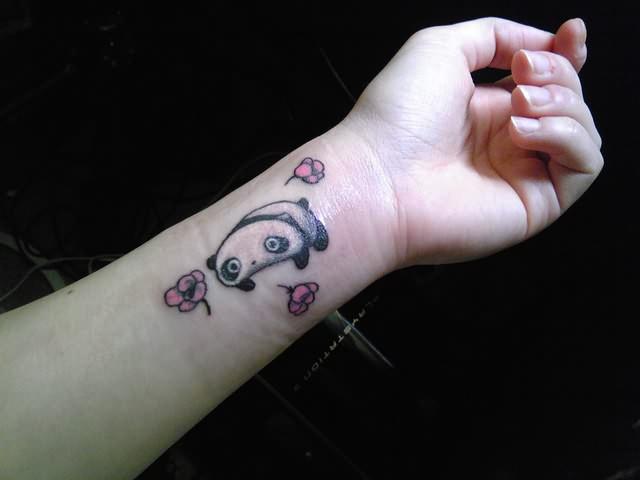 Panda bear with pink flowers tattoo