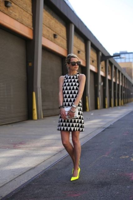 With geometric printed dress and white clutch