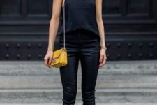 With navy blue top, black trousers and yellow mini bag