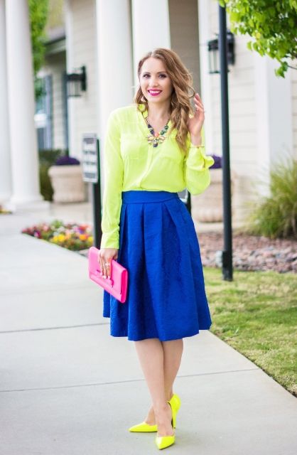 With neon yellow shirt, cobalt blue skirt and pink clutch