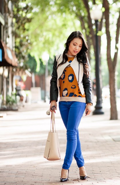With printed sweatshirt, leather jacket, cream bag and black shoes