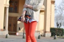 With white shirt, neutral sweater, boots and printed clutch
