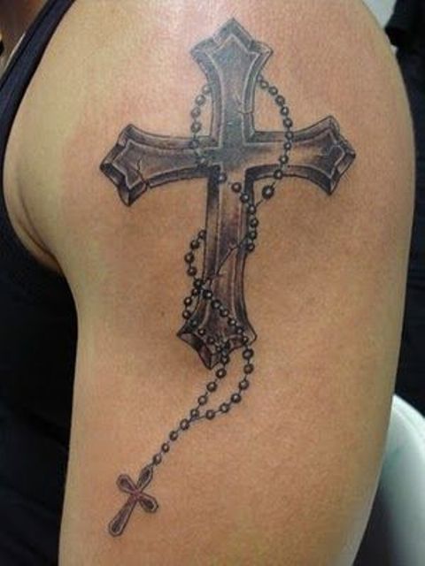 a cross with a rosary tattoo on an arm