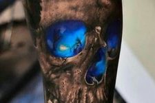 02 black and deep blue skull tattoo on an arm