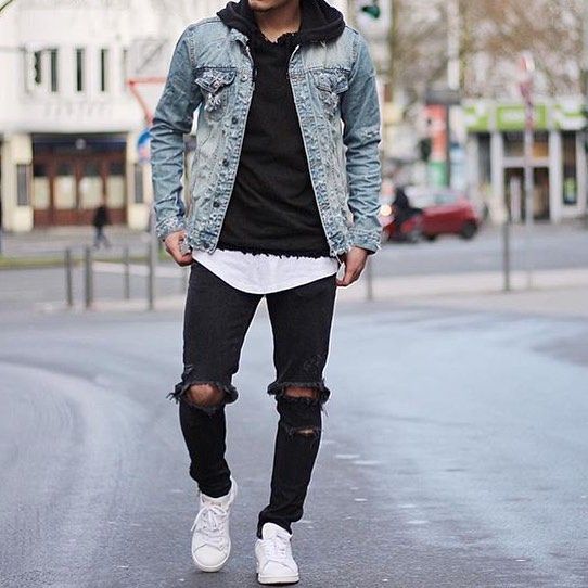 ripped jeans, a black sweatshirt, a light blue denim jacket and white sneakers