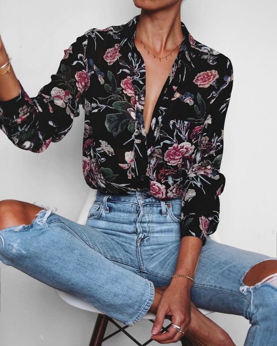 a black floral blouse, ripped blue jeans