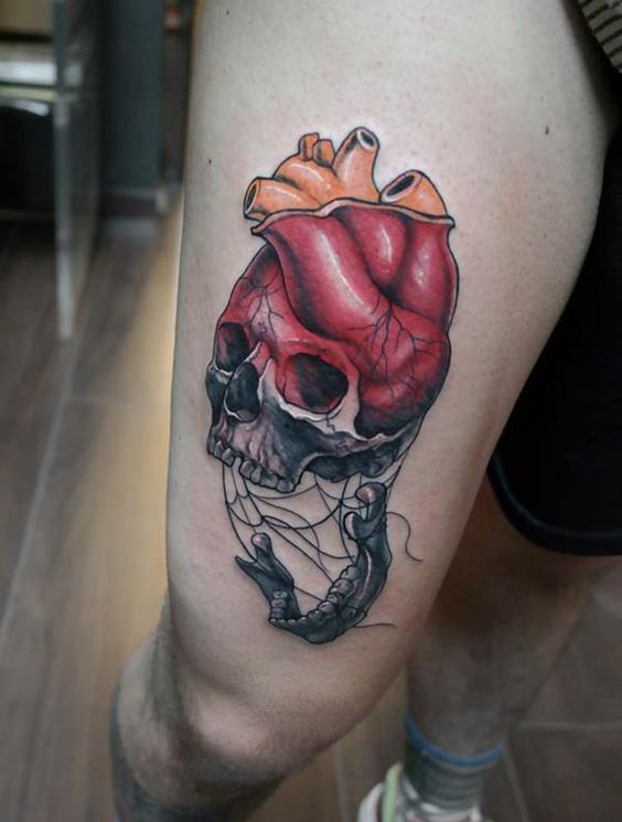 a skull and heart colorful tattoo on an arm
