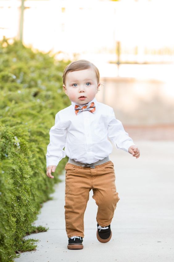 ocher pants, a white shirt, a checked bow tie and black sneakers