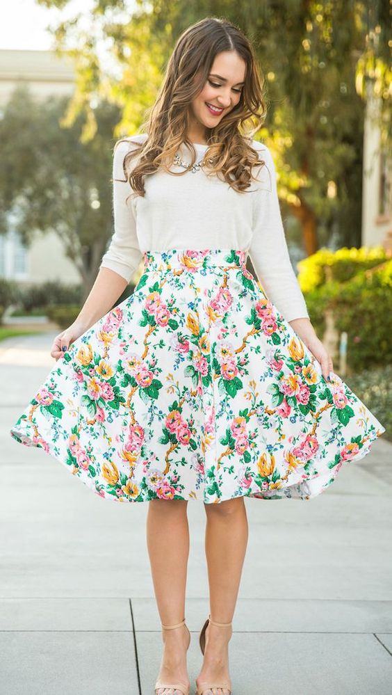 a white long sleeve, a bold floral skirt and nude heels