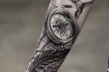 10 compass and feather forearm tattoo with a bird