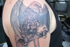15 an eagle and cross tattoo on an arm