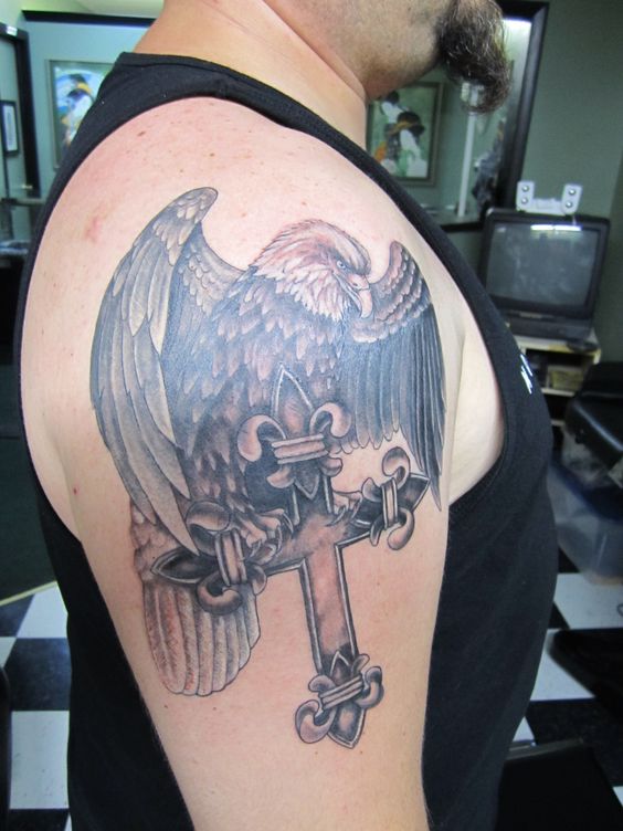 an eagle and cross tattoo on an arm