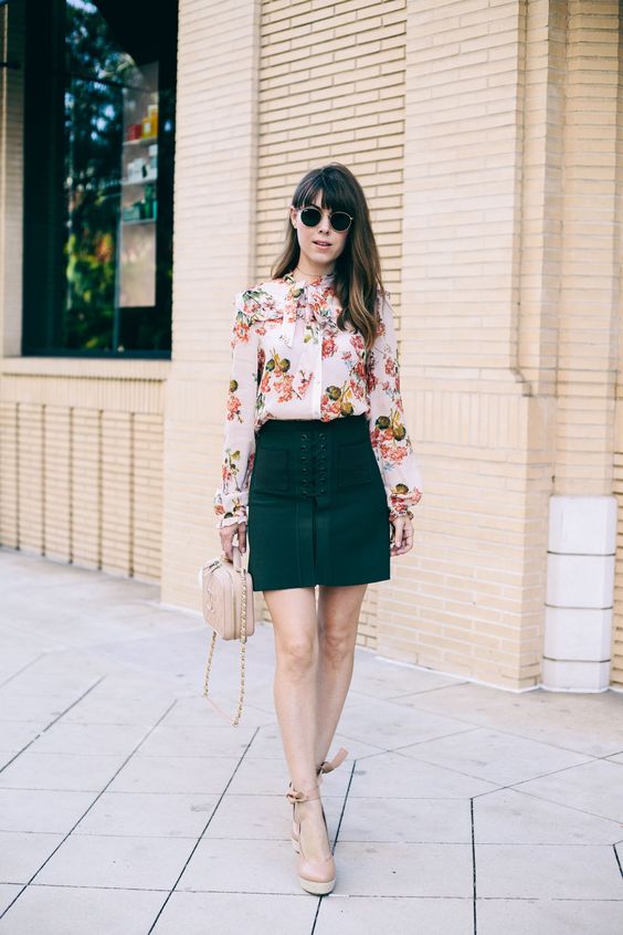 a floral blouse with a bow, an emerald lace up skirt and neutral platform heels