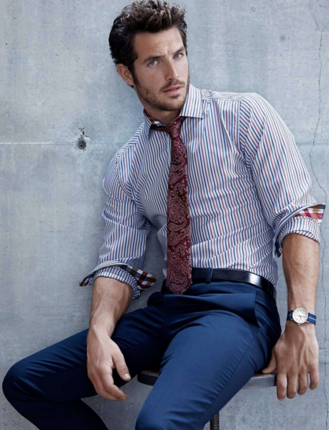 navy pants, a striped blue and red shirt and a burgundy pattern tie
