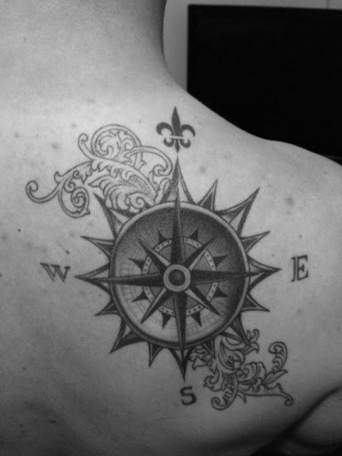 stylized black ink compass tattoo on a back