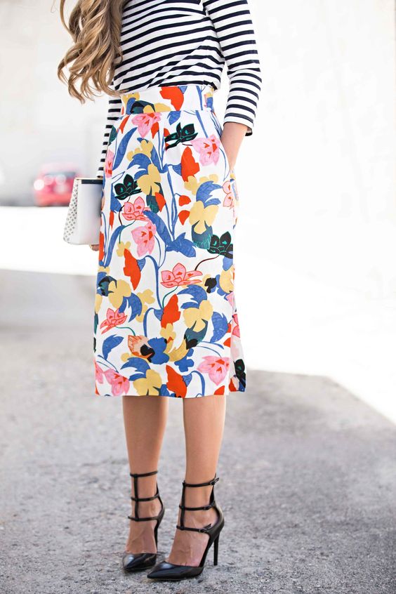 bold floral skirt, a striped long sleeve and black heels