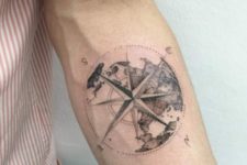 23 nautical globe compass tattoo on an arm