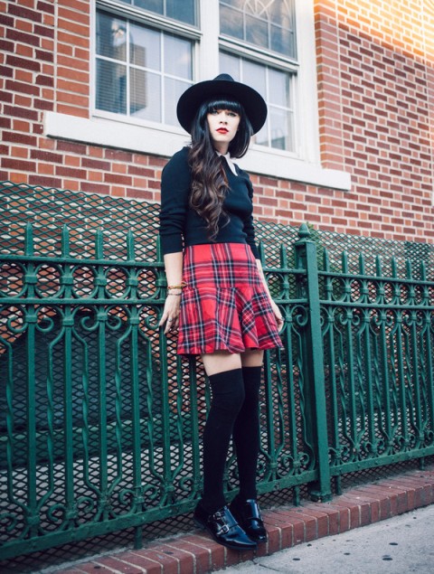 With black shirt, checked mini skirt and black hat