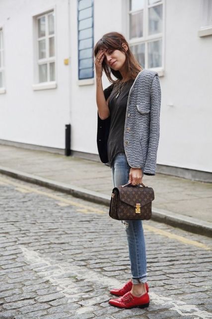 With black shirt, printed jacket, skinny jeans and printed small bag