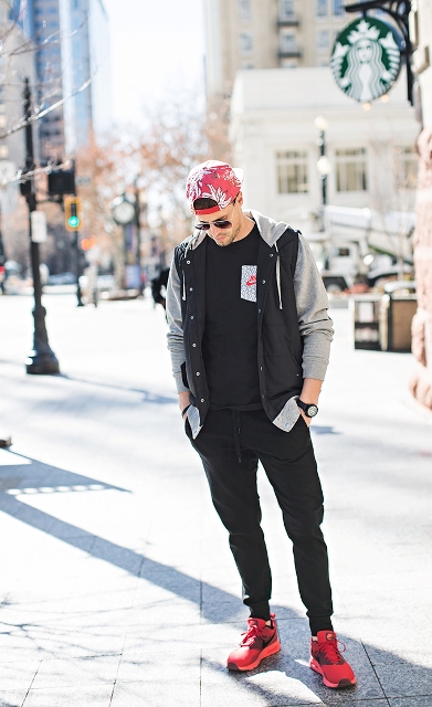 With black t-shirt, gray and black jacket, red printed cap and red sneakers