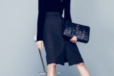 With black turtleneck, knee-length skirt and printed clutch