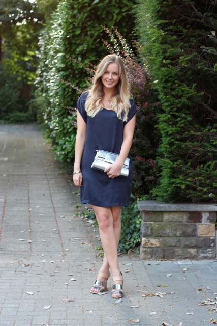 With navy blue mini dress and metallic sandals