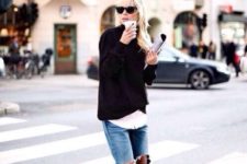 With white shirt, black sweater and distressed jeans