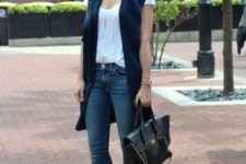 With white shirt, navy blue long vest, skinny jeans and black bag