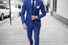 With white shirt, navy blue tie, cobalt blue jacket and brown shoes