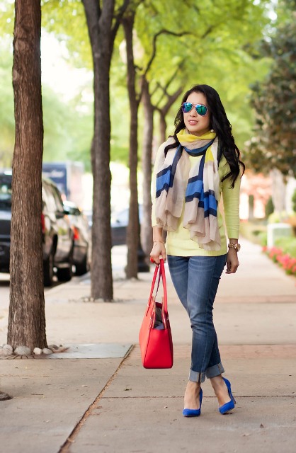 With yellow shirt, colorful scarf, cuffed jeans and red bag