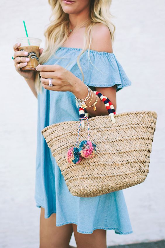a denim ruffle dress, a woven tote with pom poms, and leather sandals