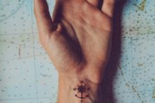 small compass 24 tattoo on a wrist