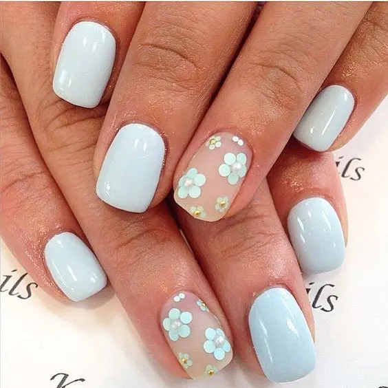 powder blue manicure and two accent nails with a matte finish and powder blue flowers