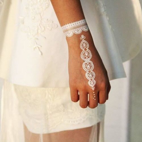 a lacey henna tattoo on the hand and wrist for a bride