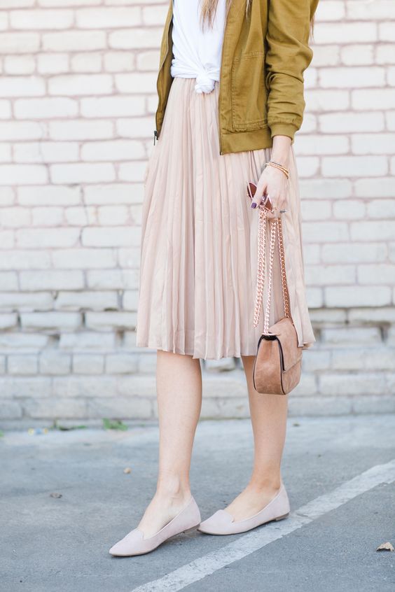 a blush pleated skirt and flats, a white tee and a mustard bomber