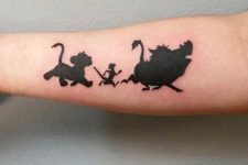 17 black ink Timon and Pumba tattoo on an arm