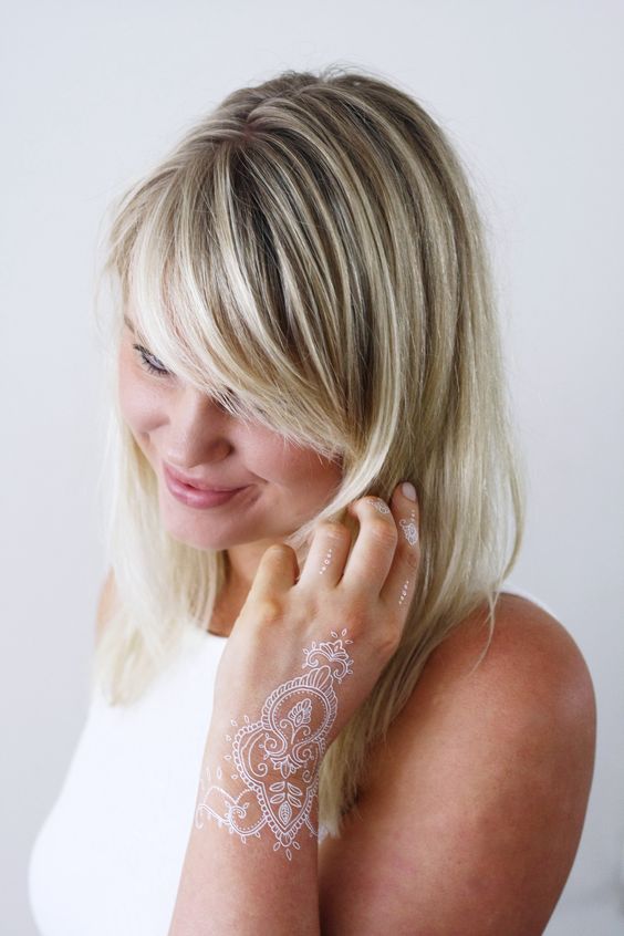 white lacey hand tattoo going on the wrist and fingers