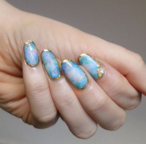 blue and pink marbelized nails with gold framing
