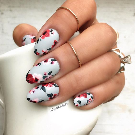 white matte manicure with bold red blooms